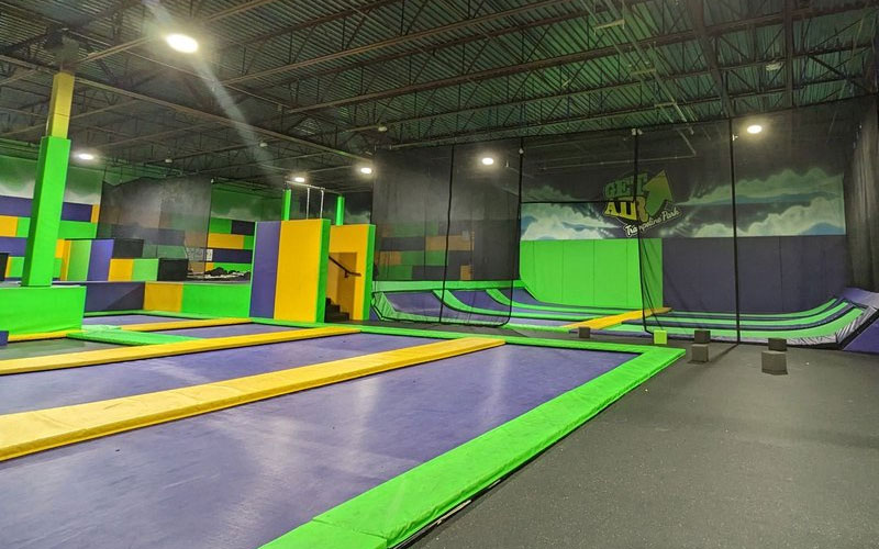 Spacious free trampoline area with professional indoor trampoline equipment and padded borders in a family-friendly park