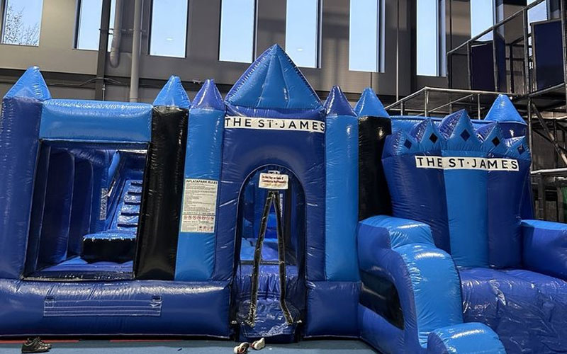 Compact inflatable castle with slides and bounce areas for toddlers in a shopping center with playground