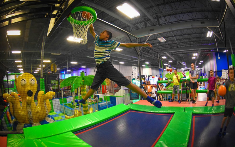 Players enjoy slam dunks in the trampoline basketball zone.