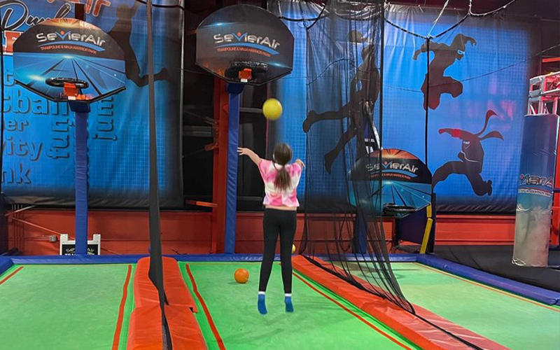 Trampoline basketball game zone encouraging slam dunks and fun