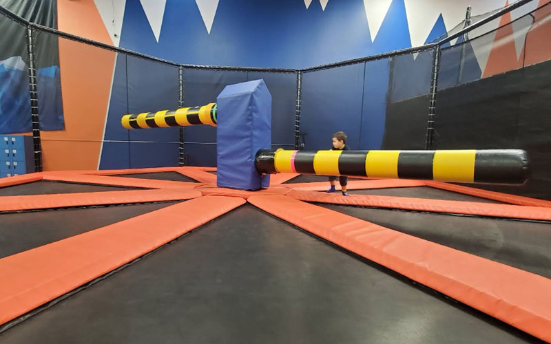 Families competing in the fun trampoline wipe out game