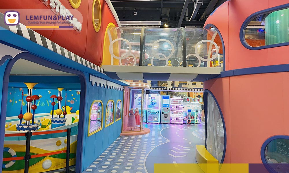 Custom macaron-style maze structure and kids ball pool with interactive projection in a candy-themed play center.