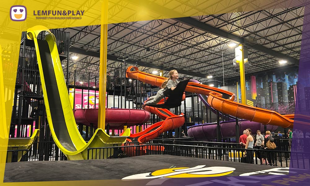 A high-angle shot of a custom-designed, vertical drop fly slide in a commercial indoor playground, demonstrating premium equipment quality and thrilling design.