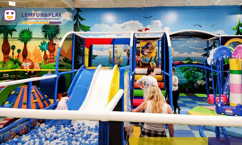 A dynamic photograph of a large, three-lane wave slide made of durable plastic, integrated into a themed structure, ending directly in a large, contained ball pool filled with green and yellow balls.