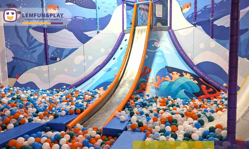 Macaroon Themed Indoor Playground Equipment in Canada featuring a volcano climbing game and soft-landing ball pit.
