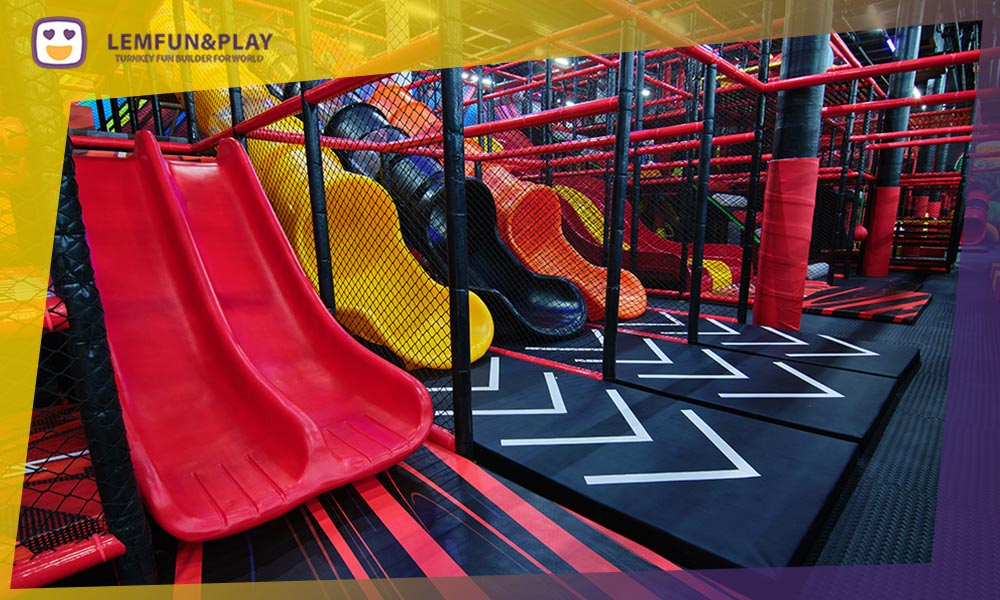 Commercial indoor amusement playground slide game area emptying into a large ball pit pool.