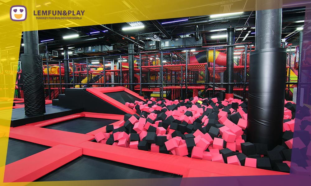 Professional indoor trampoline park foam pit featuring high-density safety foam blocks and thick PVC edge padding.