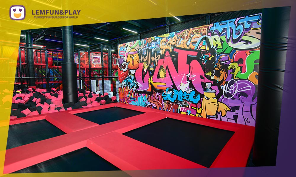 Large commercial free trampoline area grid with heavy-duty jumping mats and protective boundary safety pads.