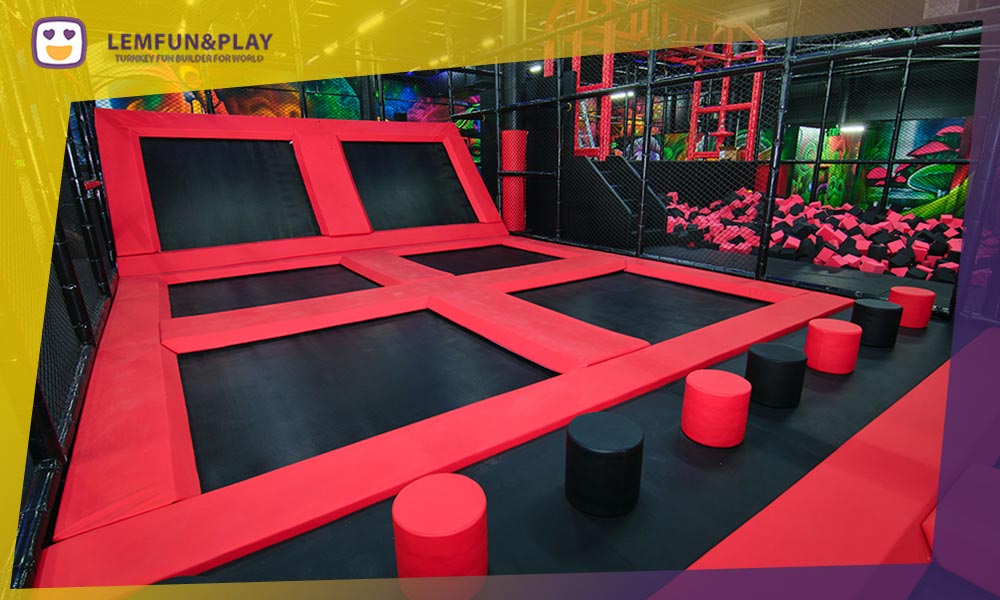 Long inclined slope trampoline race tracks with heavy-duty padding dividers for competitive indoor play.