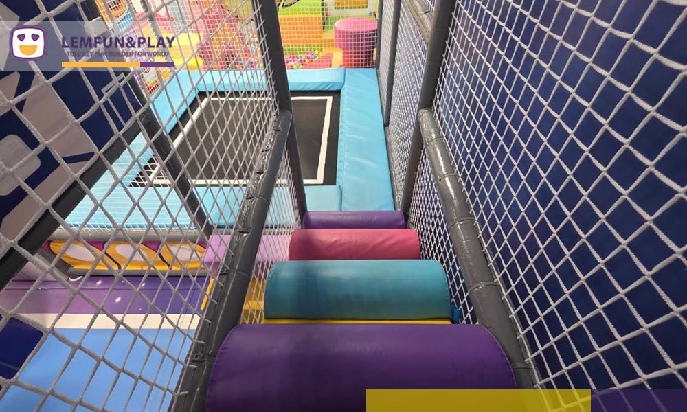 Heavy-duty kids trampoline area featuring pastel pink and baby blue safety padding.