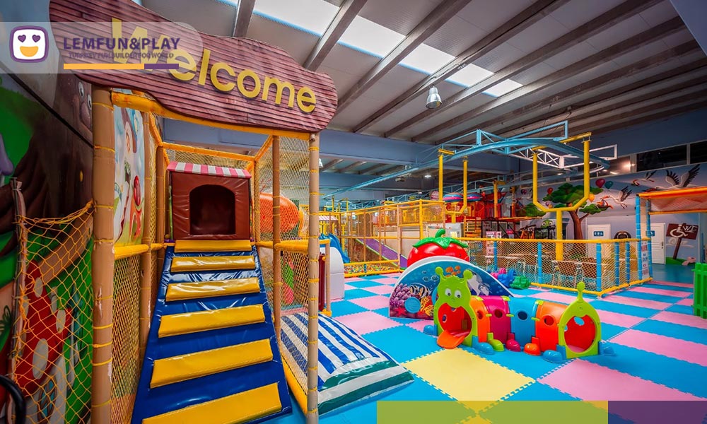 Custom toddler area featuring soft play tunnels and pastel macaroon aesthetics.