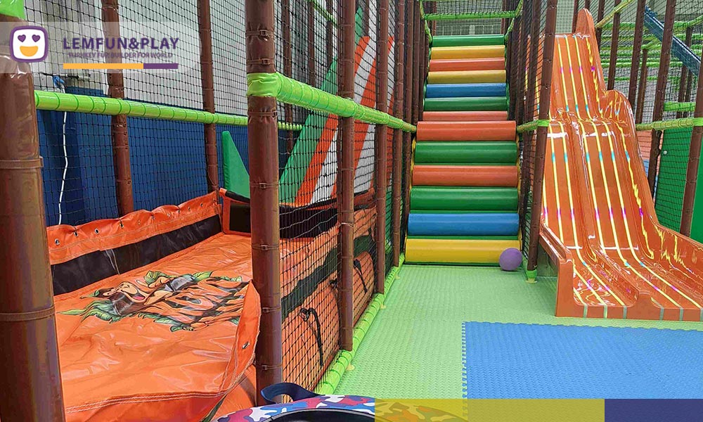Reception desk and dry-ski donut slide featuring hot sale indoor play area equipment with vibrant rainbow stairs and inflatable tubes.