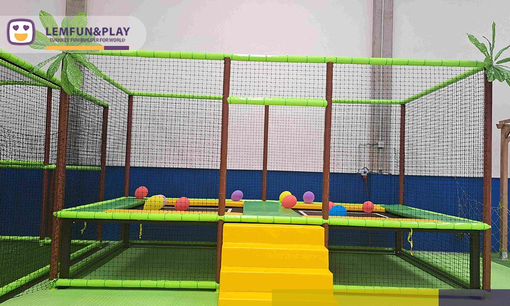 Dedicated kids trampoline area engineered with high-tension jumping mats, padded yellow steps, and heavy-duty protective steel frames.