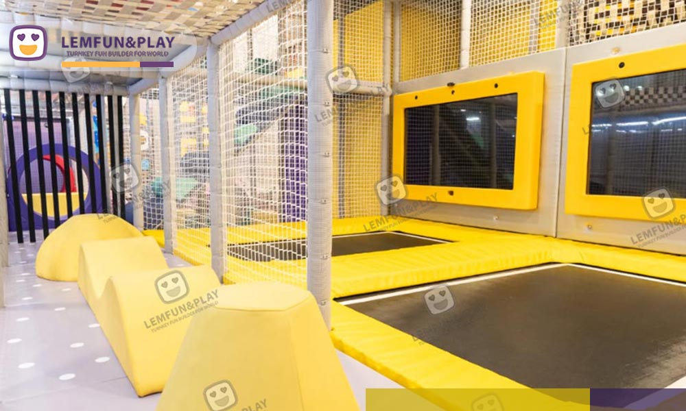 High-tension trampoline beds with wall-mounted interactive gaming monitors for teenager active play at momoland playhouse.